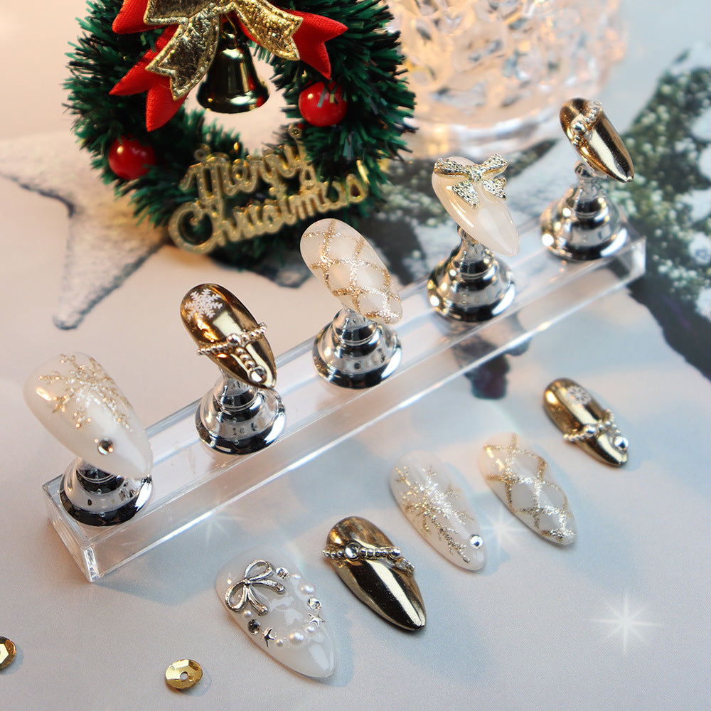 Handcrafted festive oval nails with white and gold decorations.