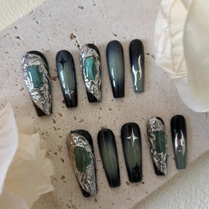 Handcrafted emerald nails with bold 3D metallic details.