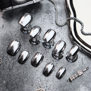 Silver metallic coffin nails with a glossy finish displayed on a dark surface.