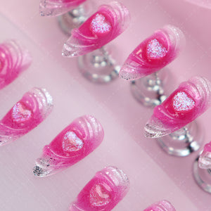 Individual pink press-on nail featuring a delicate heart accent.