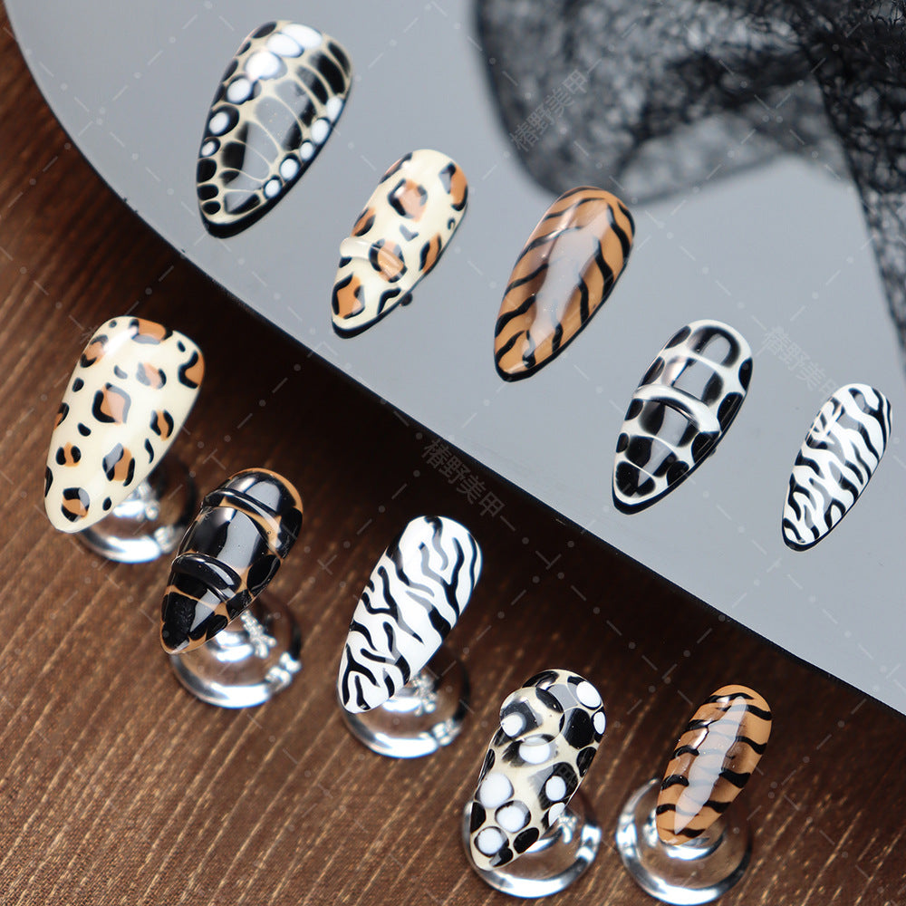 Beige and black animal-print press-on nails displayed elegantly.