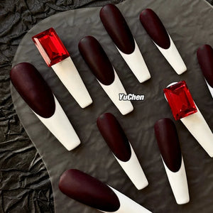 Close-up of bold blood red and white coffin nails.