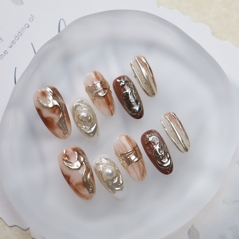  Oval nails with gold accents and amber tones arranged elegantly for a clear view.