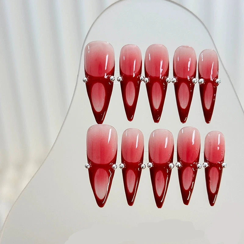 Handcrafted red stiletto nails showcasing bold ombre design.