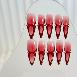 Handcrafted red stiletto nails showcasing bold ombre design.