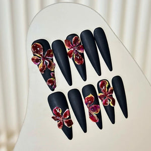 Matte black stiletto nails with handcrafted 3D floral accents