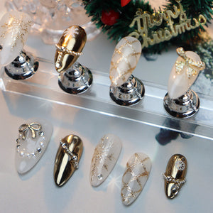 Long oval nails with gold accents and holiday-inspired motifs.