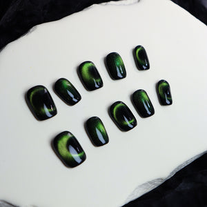 Shimmering green nails in a rounded design on a white background.