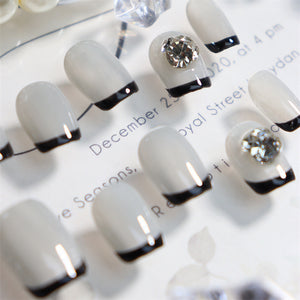 Stylish white nails with black French tips and diamond details