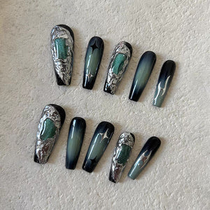 Sleek coffin-shaped nails with emerald ombre and unique metallic accents.