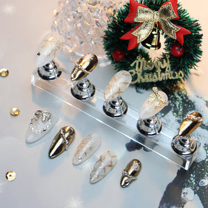 Christmas-themed oval nails featuring gold and white hand-painted designs.