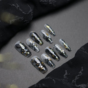 Durable and lightweight bamboo press-on nails in gold and black.