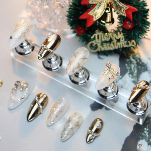 Festive oval nails with snowflakes, bows, and metallic finishes.