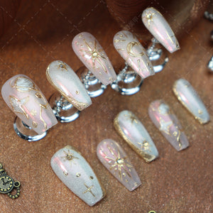 Celestial-inspired almond nails with pink and gold hues.