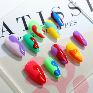 Close-up of almond press-on nails with multicolor details.