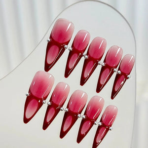 Elegant long red ombre nails with sleek stiletto shape.