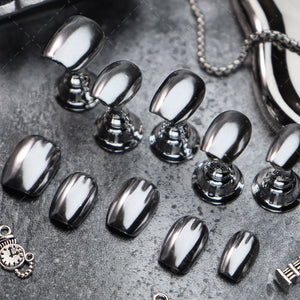 Close-up of futuristic silver coffin nails reflecting light elegantly.